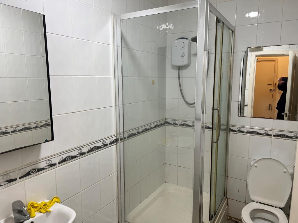 Lot: 46 - STUDIO FLAT FOR IMPROVEMENT - Shower room with white tiles and white suite